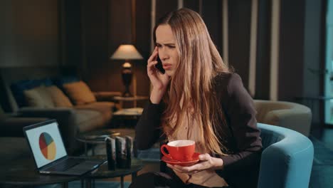 business woman calling phone at hotel lounge. serious woman using mobile phone