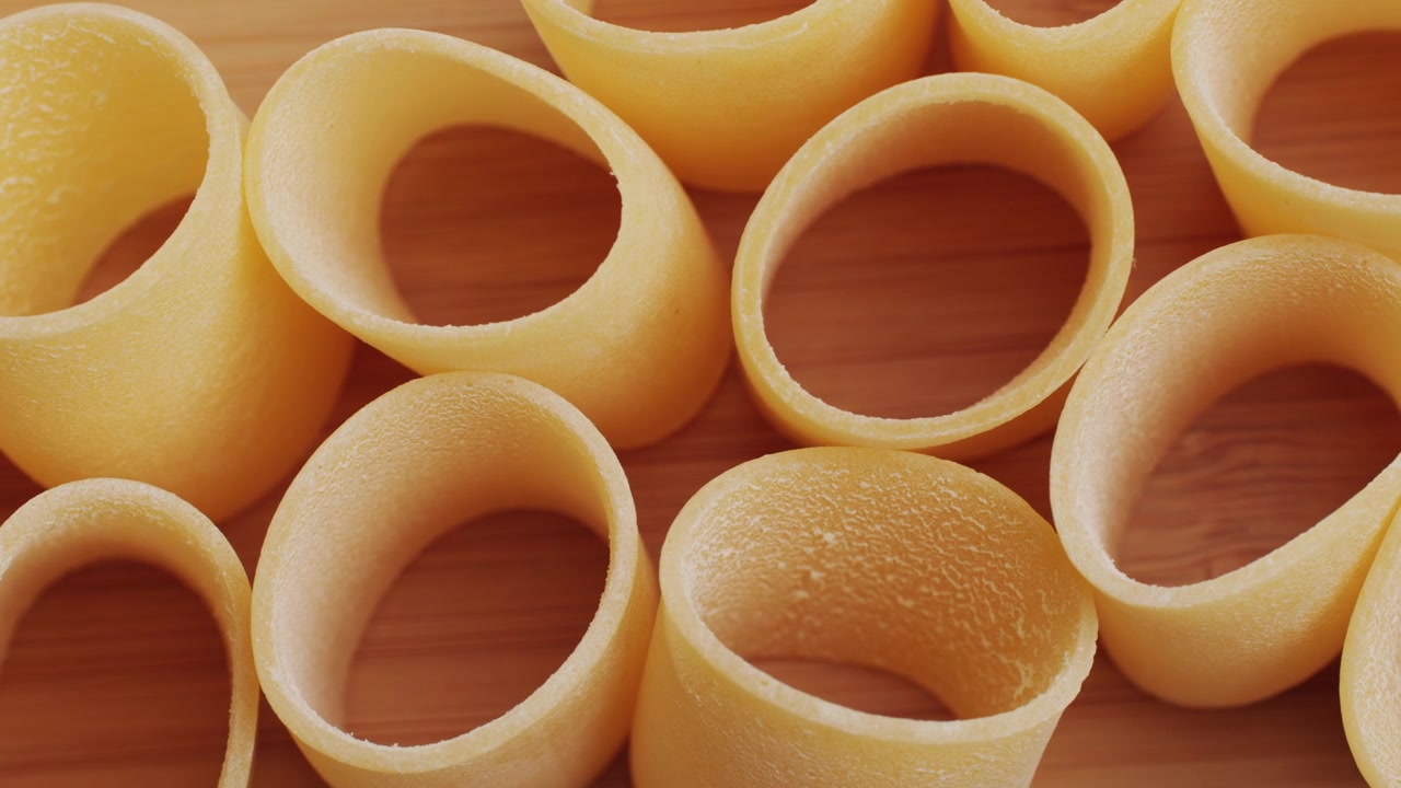 木の表面にある未調理の乾燥パスタのクローズアップ