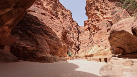 steep cliffs of sandstones carved by the wind power over the centuries. footage among the rocks of the al siq canyon in petra, southern jordan, west asia. low angle view.