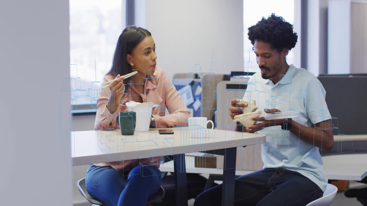 På kontor, to personer spiser frokost med animation af arkitektoniske skitser overlejret