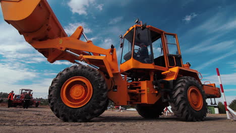 wheel loader with lifting excavator bucket moving on construction site