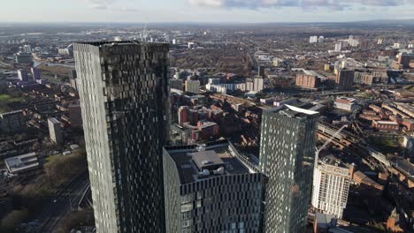 vuelo de drones aéreos de 4k 60fps en el centro de la ciudad de manchester con vistas a la torre elizabeth y tres torres con castlefield y un edificio en construcción en el fondo