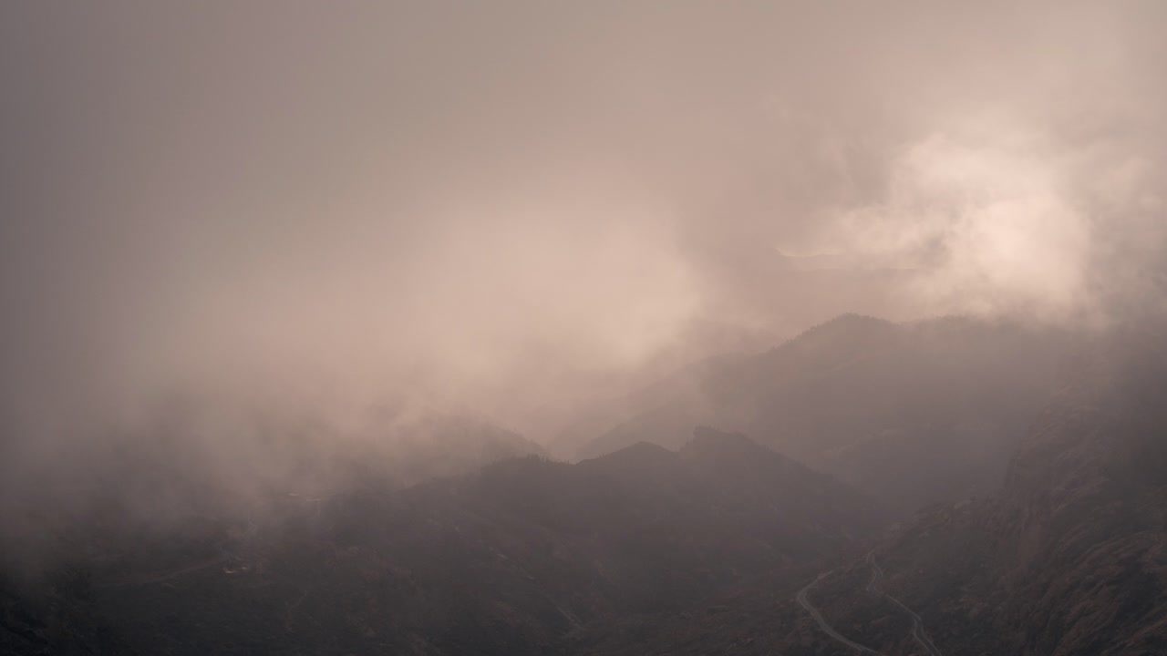 Dramatic timelapse of a cloudy valley in Gran Canaria at sunset. Warm golden light breaks through the mist, creating a breathtaking and cinematic scene. Perfect for nature, travel, and landscape