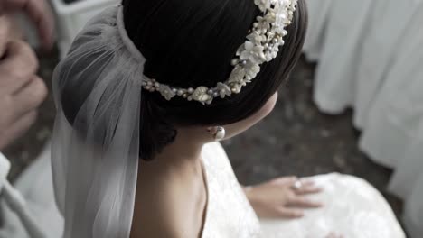 decorating the bride diadem with a white, thin cloth, close up view from above