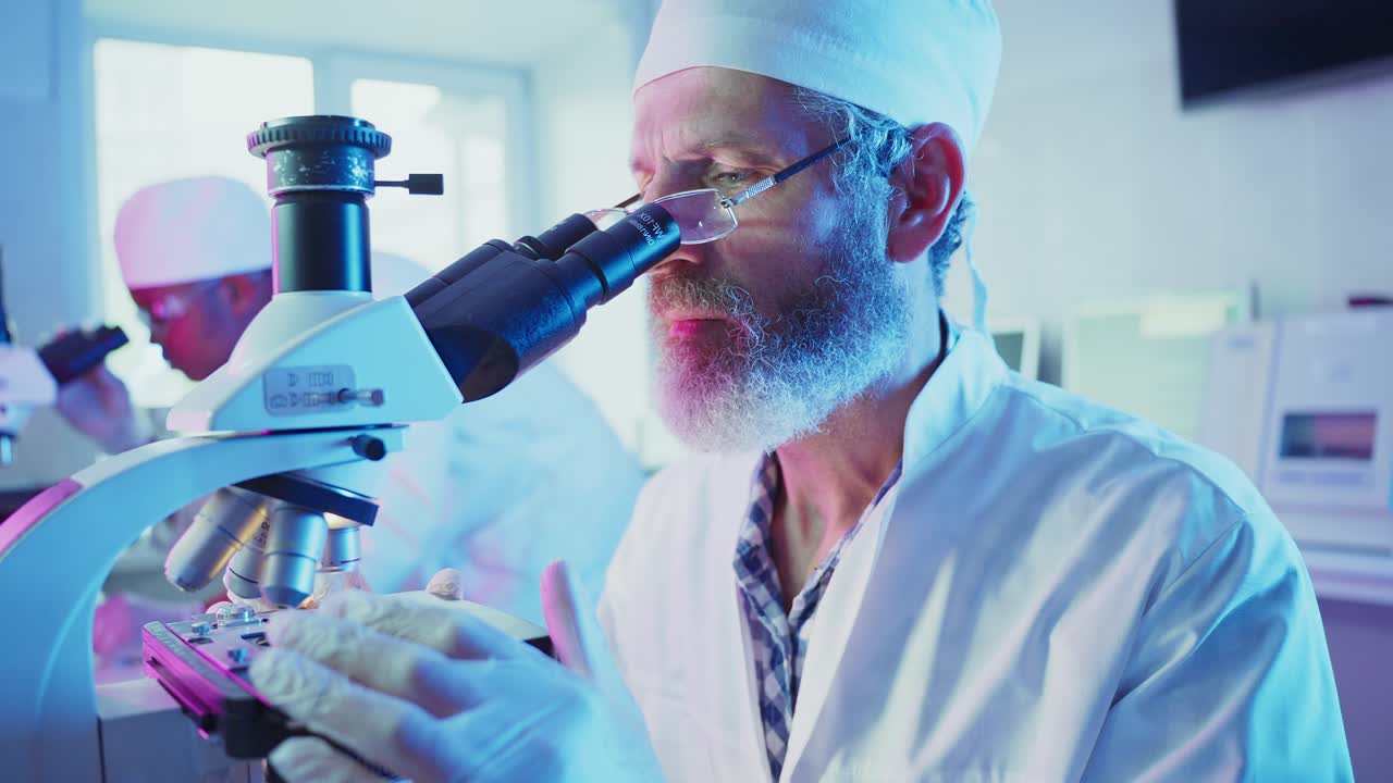 Focused Scientist Examining Samples with a Microscope in a Modern Laboratory