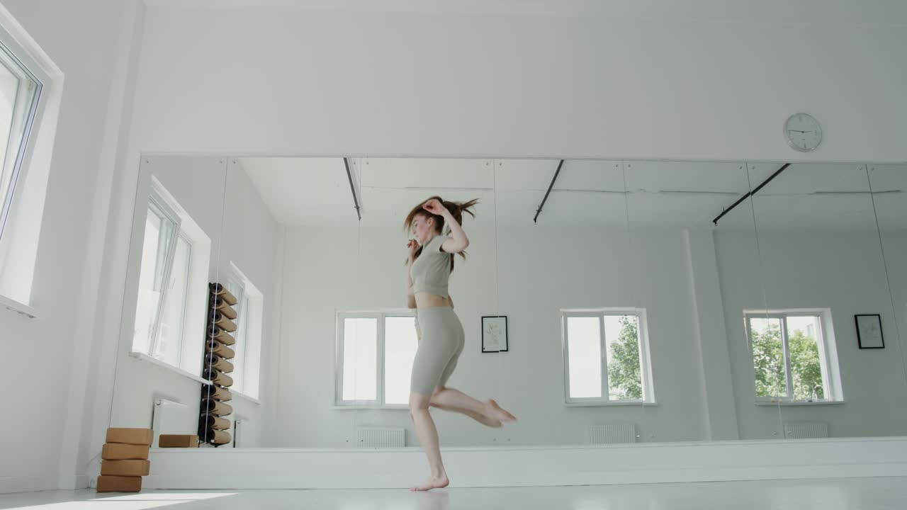 여성 댄서 가 스튜디오 에서 현대 댄스 를 연주 하고 있다