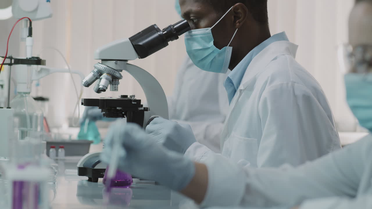 Black Male Scientist in Face Mask Doing Research