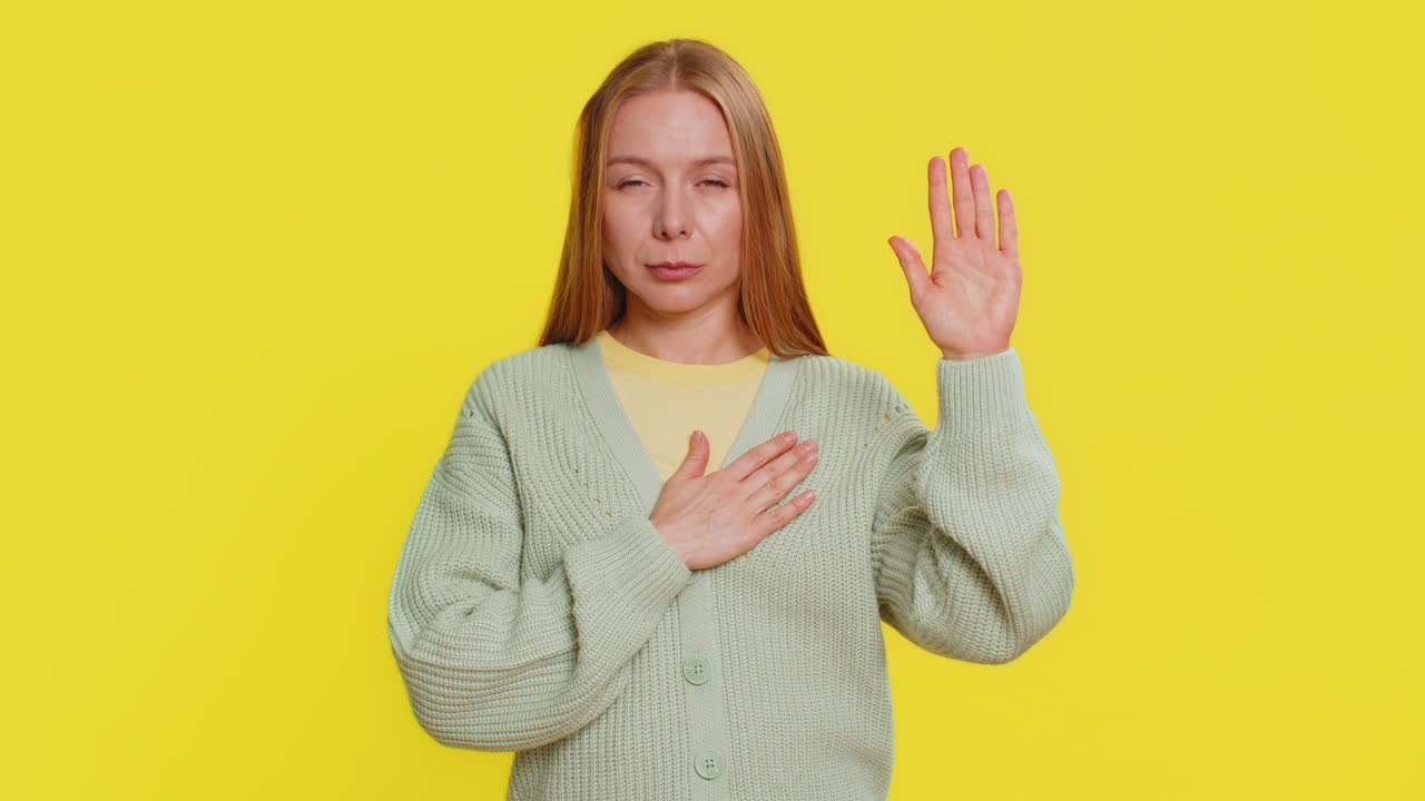 여자가 손을 들어 맹세를 하고, 정직하고 진실을 말하겠다고 약속하고, 가에 손을 고 있다.