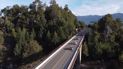 disparo de establecimiento volando sobre una carretera con autos pasando en villa la angostura, patagonia argentina