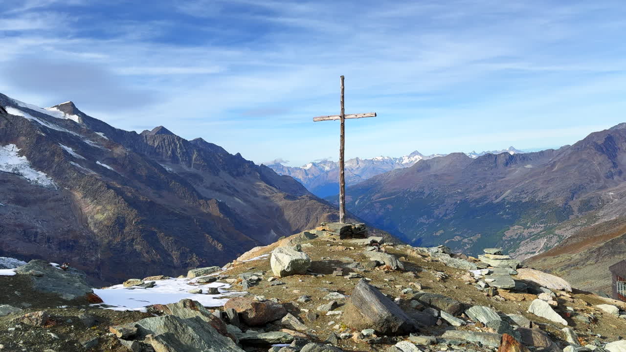 la cima de la montaña taschhorn cristiano católico jesús cristo cruz en el pico rocoso nevado saas tarifa saastal zermatt suiza alpes suizos religiosos pacíficos cielo azul altas nubes deslizamiento lento a la izquierda