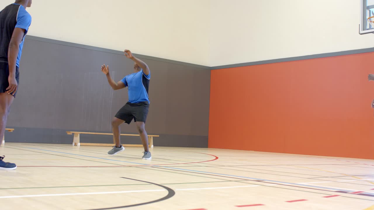 Melempar bola voli ke udara, atlet pria Afrika-Amerika berlatih set dan voli di gym.
