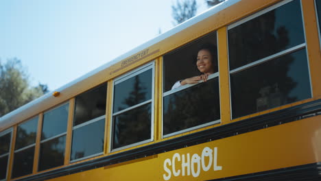 Afroamerikanisches-Mädchen,-Das-Aus-Dem-Schulbusfenster-Schaut.-Schüler-Steht-Im-Bus.