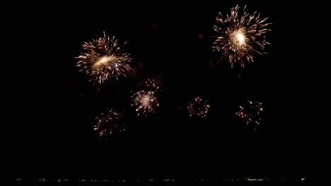 llenando los cielos con luces de colores brillantes en una playa de un popular destino turístico durante un festival internacional de fuegos artificiales