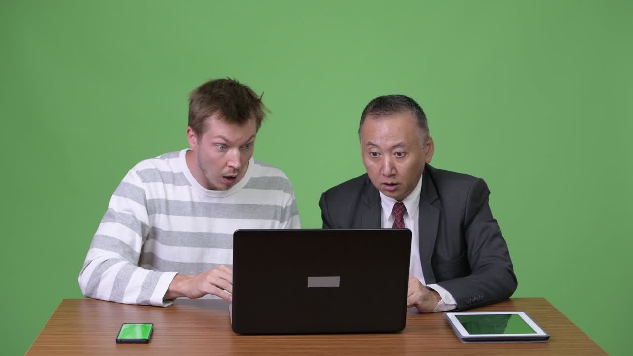 성숙한 일본 사업가와 젊은 스칸디나비아 사업가가 함께 일하고 있습니다.