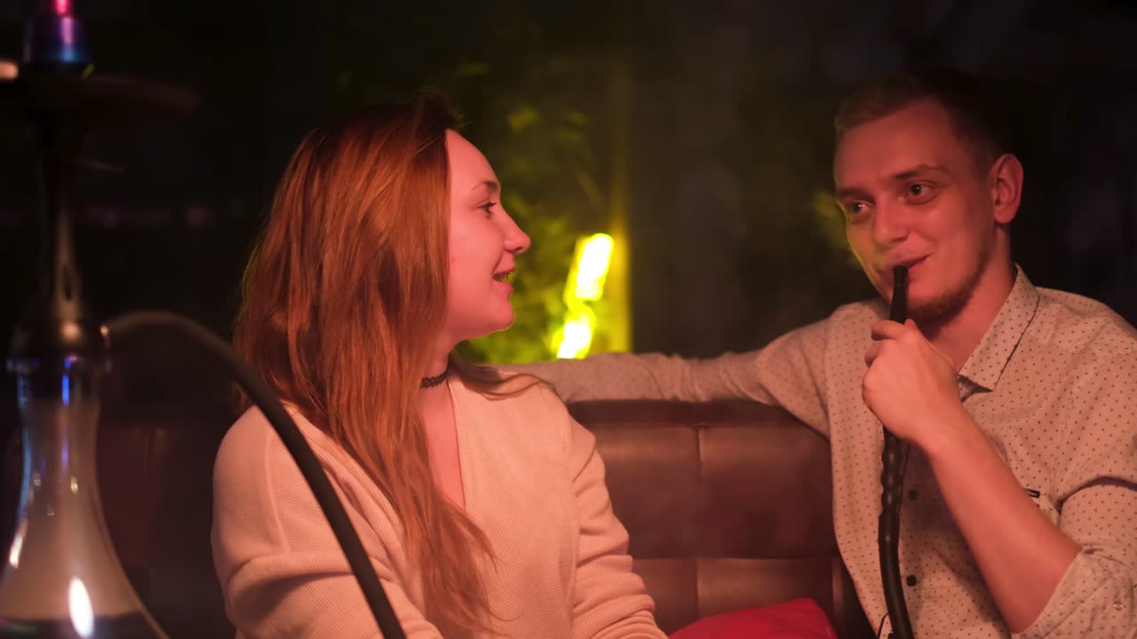 한 커플 이 라운지 에서 호카 를 즐기고 있다