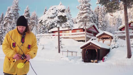 fisherman with ice fishing rod on a winter landscape village