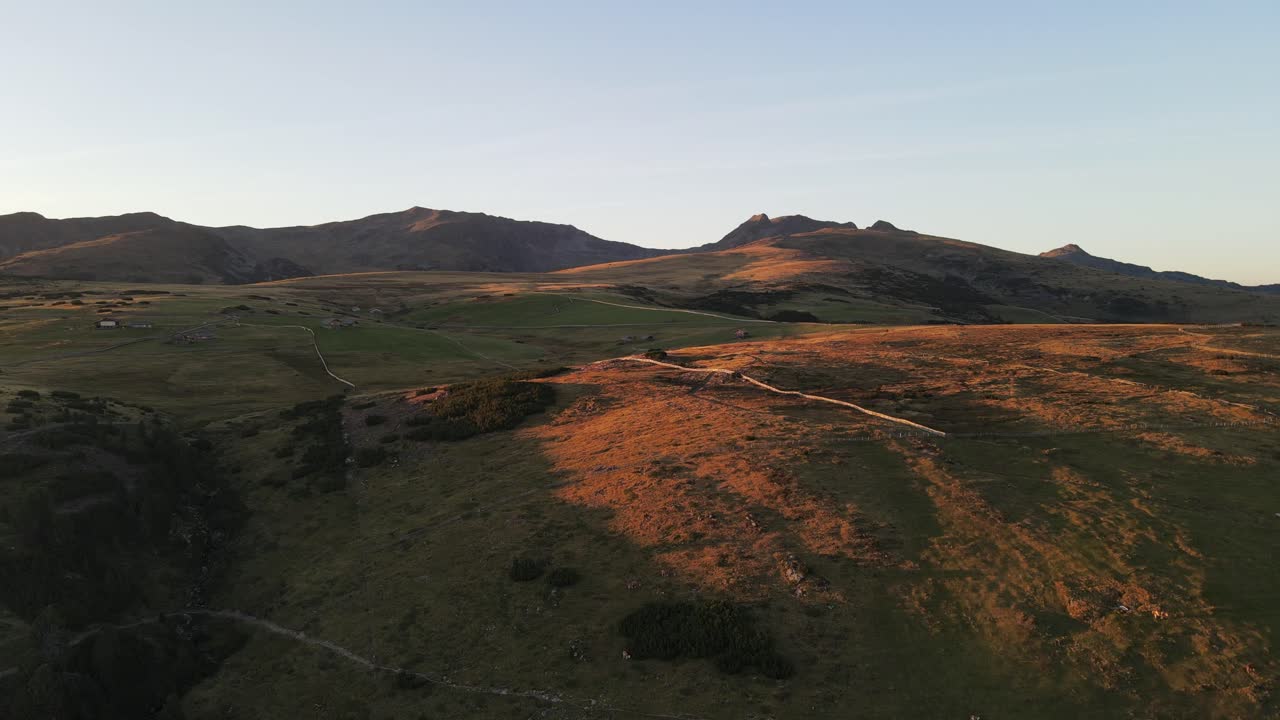 aerial drone shot of the alps while sunset with huts and farmland, beautiful nature