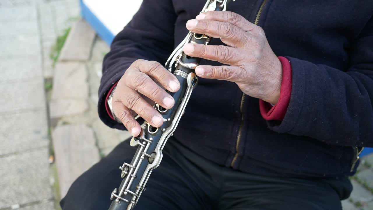 Un musicista che suona un clarinetto per strada