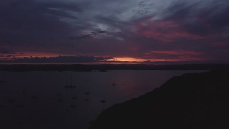 aerial shot of sun setting in russell, the bay of islands as boats anchor in the water