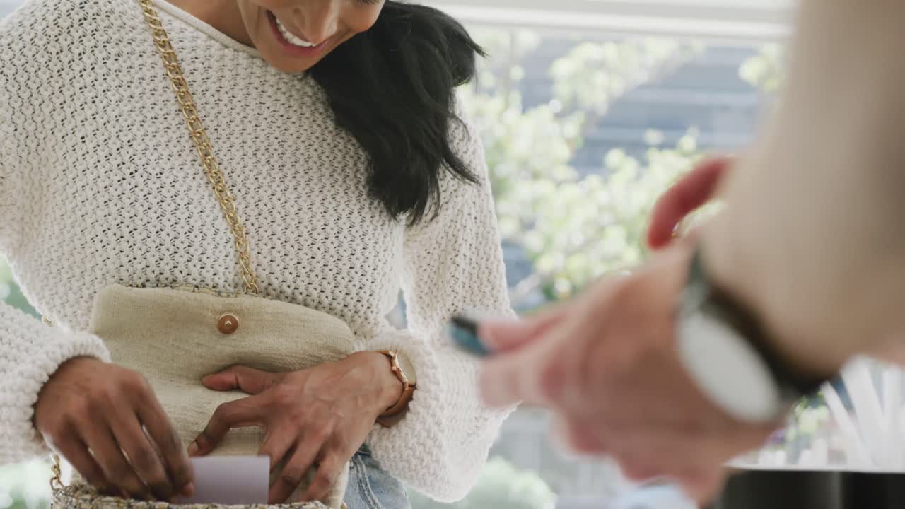 카페 에서 신용 카드 로 지불 하는 행복 한 이중 인종 여성