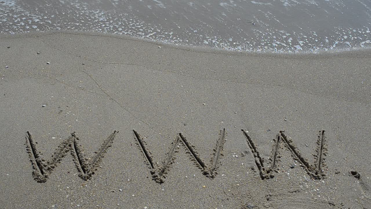 Ordet www håndskrevet i sand på en strand. Optagelse på stranden.