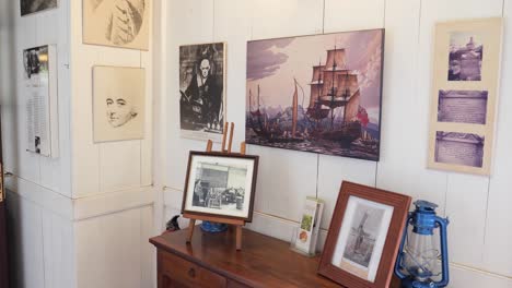 historical museum exhibit: portraits, ship paintings, and antique photographs