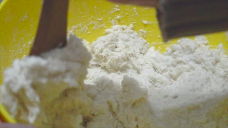primer plano mezclando masa de pizza con cuchara de madera