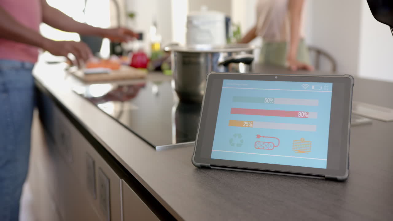 Using tablet for monitoring energy usage while cooking in modern kitchen