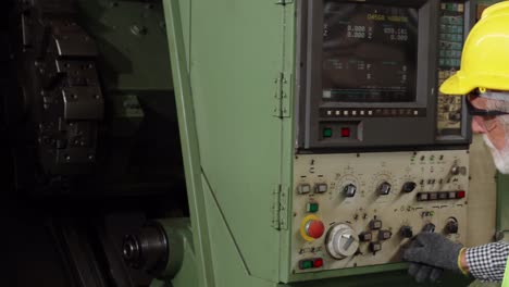 trabajador sénior de la fábrica enseña cómo usar el equipo de la máquina en el taller de la fábrica