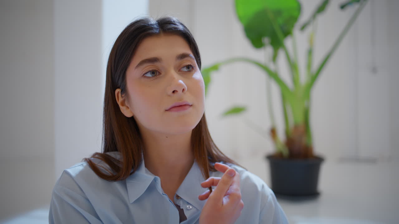 chica morena tocando el cabello en casa de cerca. hermosa mujer serena mira la cámara