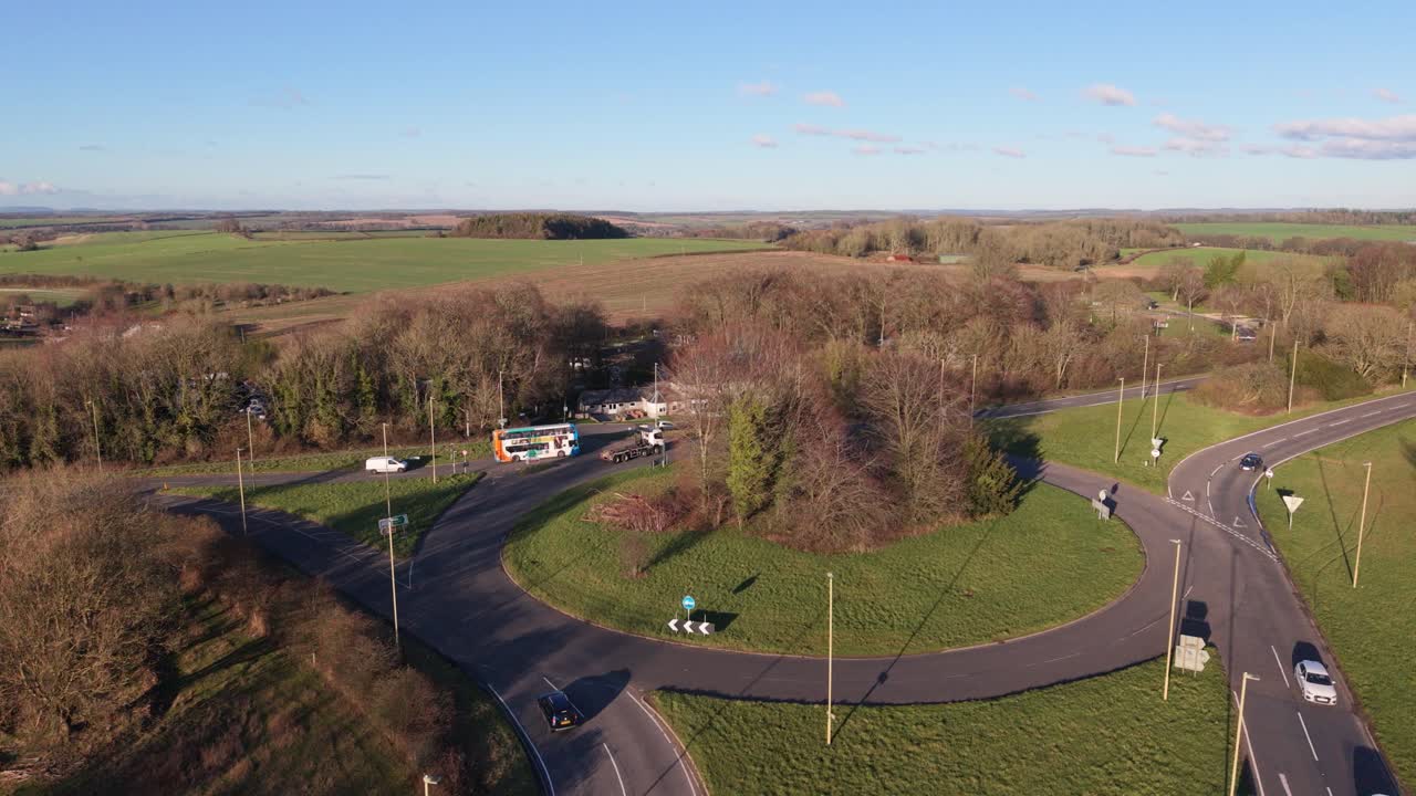 Luftfoto af Percy Hobbs rundkørsel, Alresford Road, Winchester, Hampshire, med udsigt over et omfattende bølgende landskab i South Downs Nationalpark i den sene eftermiddagssol med blå himmel