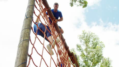 Personas-En-Forma-Escalando-Una-Red-Durante-La-Carrera-De-Obstáculos-4k