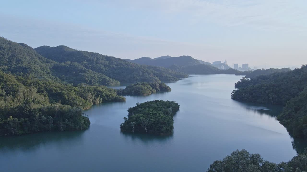 홍콩 신문 저수지의 댐과 관제탑 옆 산의 역동적인 상승 공중 촬영