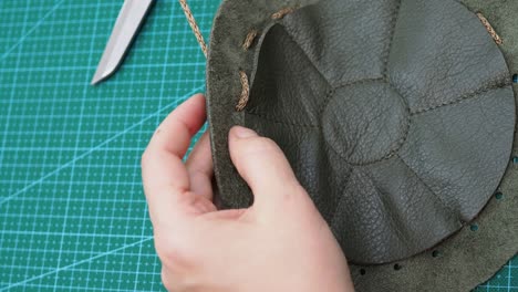 craftsman inserts a string in the sewn pouch