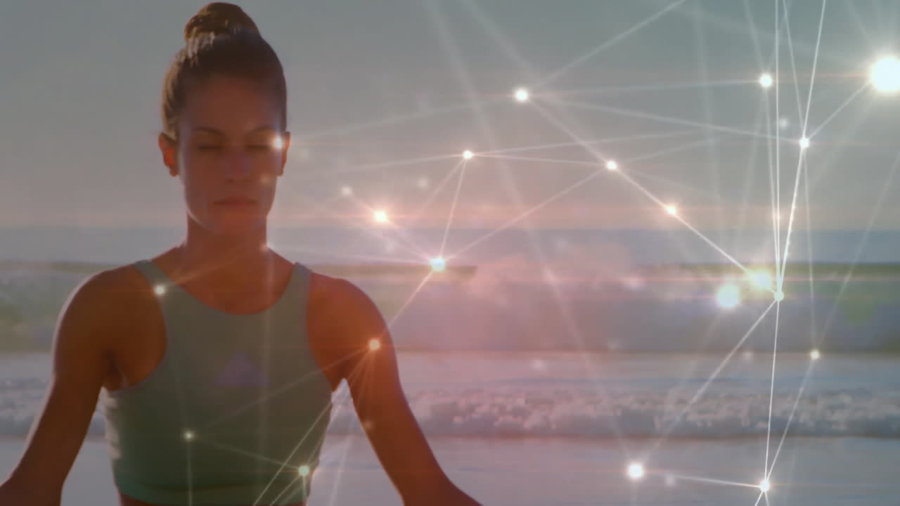 Meditating on beach, woman with glowing network connections in animation overlay