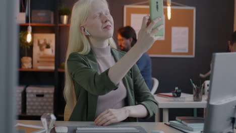 young woman taking a selfie in a modern office