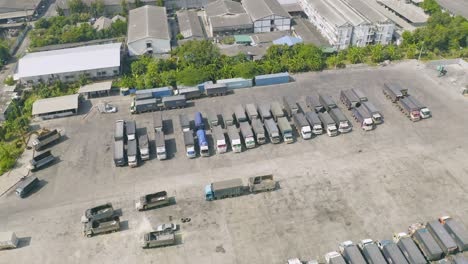 aerial top view of truck cars parking stock lot row in industry factory, dealer inventory import and export business commercial, automobile and automotive industry distribution logistic transport