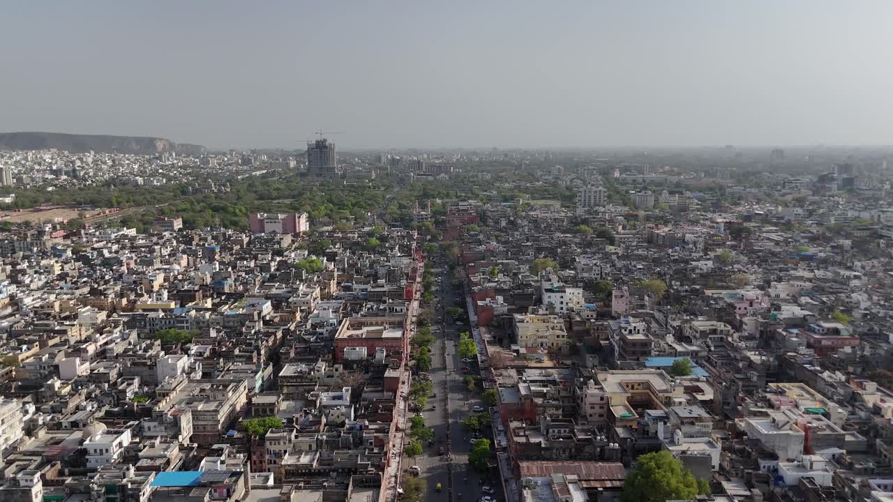 Scenic drone view of a hilltop fort surrounded by dense city settlements and buildings in the background