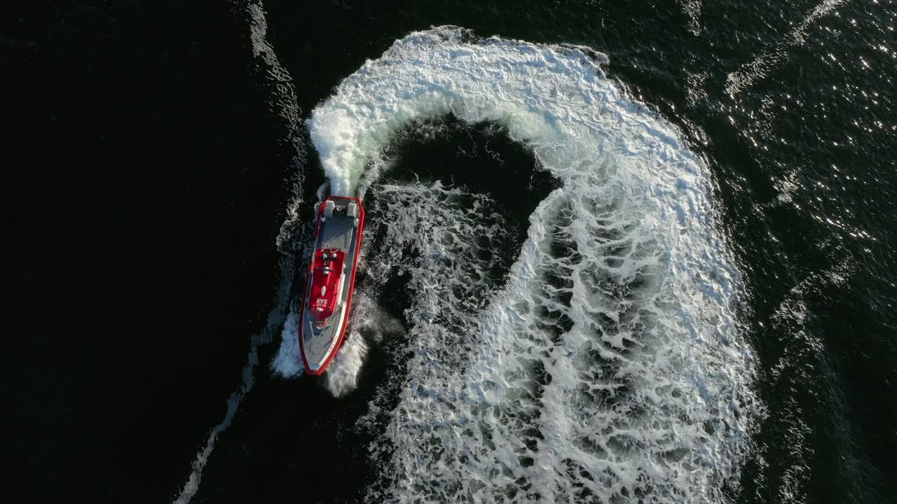 A boat moves swiftly across serene waters in an archipelago, with rocks dotting the landscape under a clear sky during a beautiful sunset