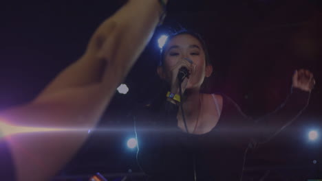 female singer performing on concert stage, with animated music notes and lens flare graphics