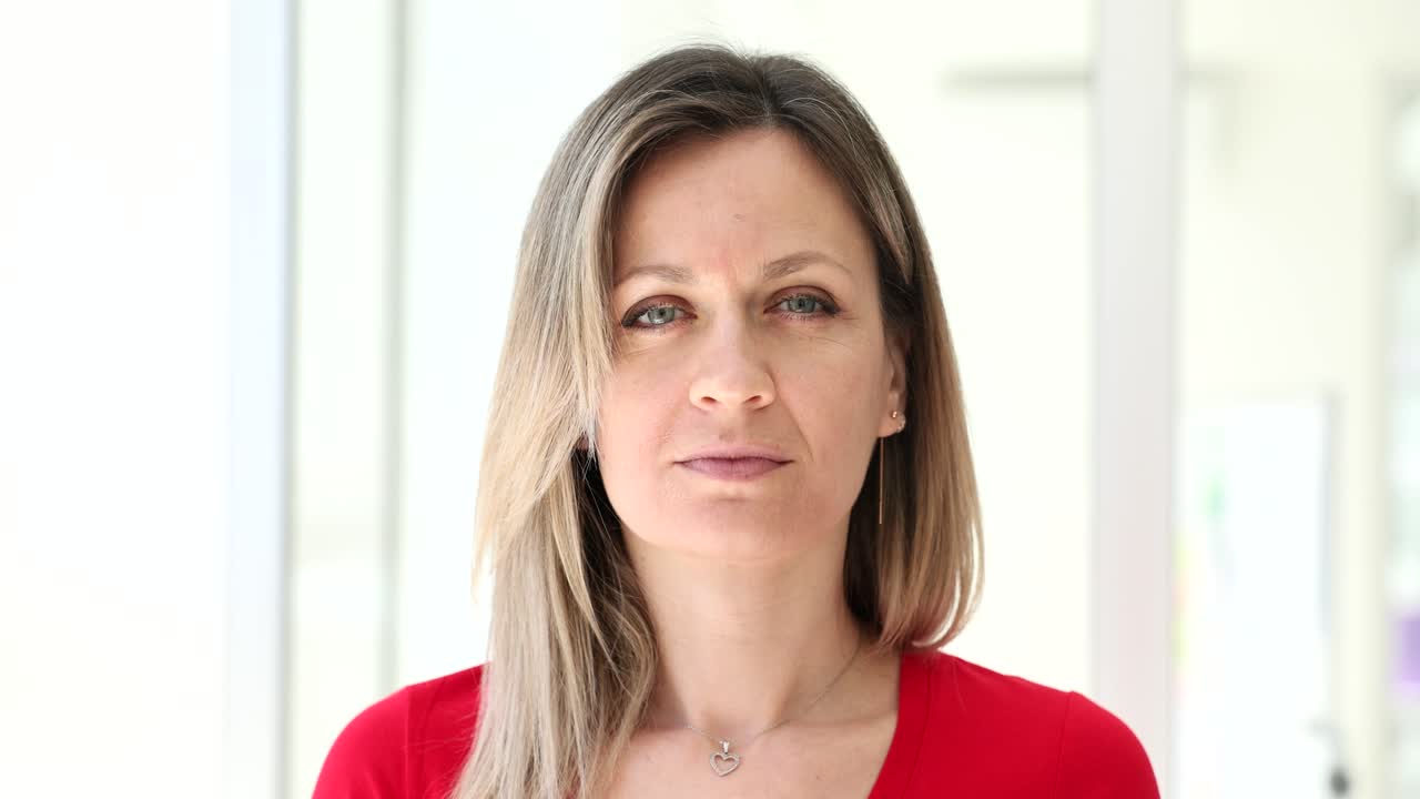 Woman creating a forced smile with her fingers