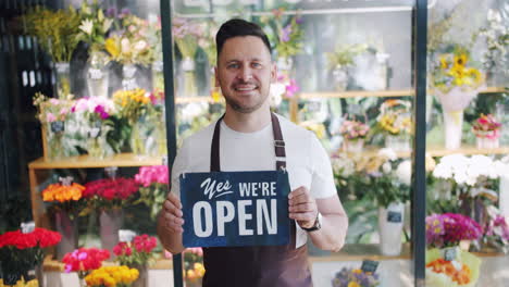 florist shop owner holding open sign