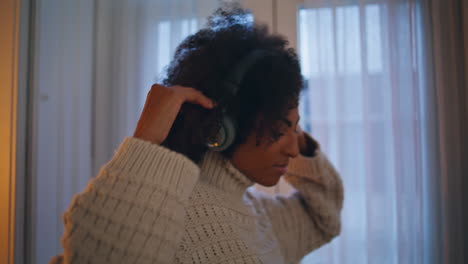 Closeup-carefree-girl-dance-movements-home.-Black-hair-headphones-woman-dancing