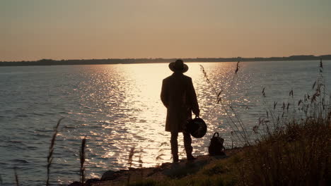 man contemplating sunset over the river