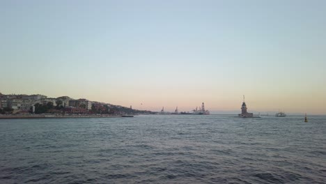 evening, cinematic slow-mo, the view of uskudar and the adjacent maiden's tower from a ferry sailing along the istanbul bosphorus