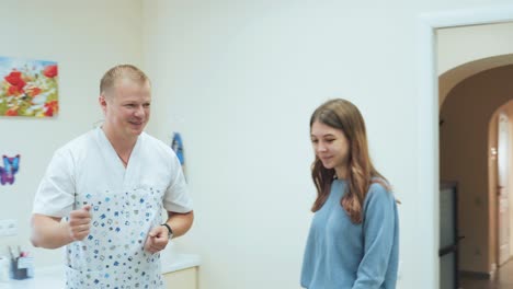 a young girl enters the office of a dental clinic and sits in the dentist chair. patient at the doctor's office