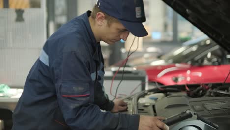 mecánico de automóviles inspeccionando el motor del automóvil en el taller