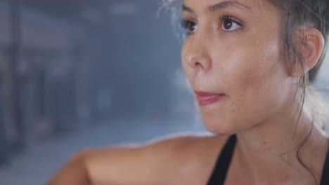 video de una mujer caucásica en forma y cansada descansando después de entrenar en el gimnasio