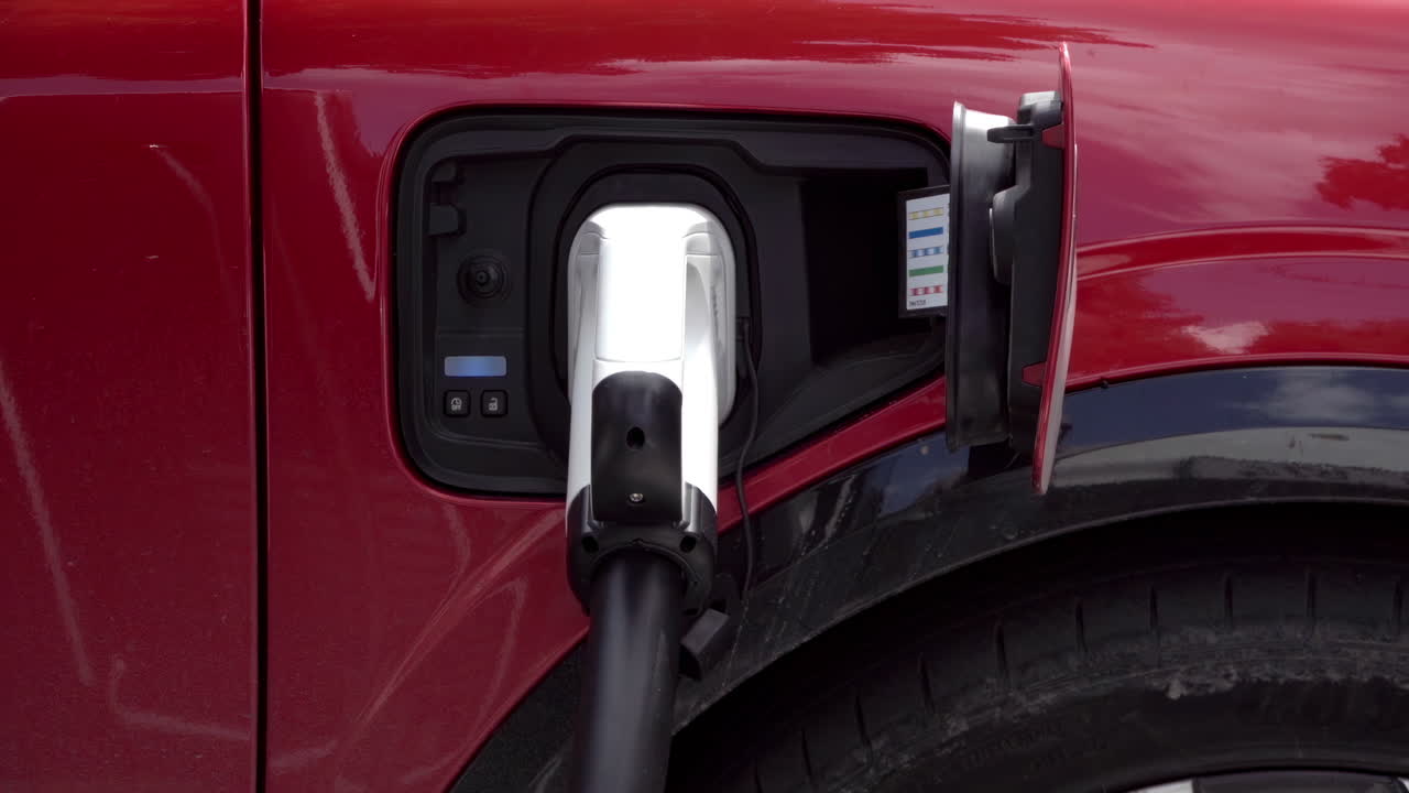 Close up of a red, electric car charging