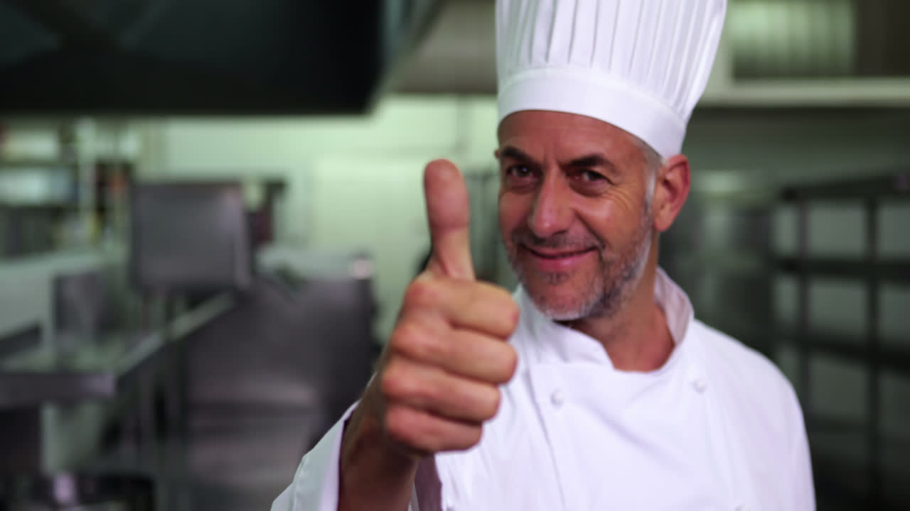 jefe de cocina dando pulgares hacia arriba y sonriendo a la cámara